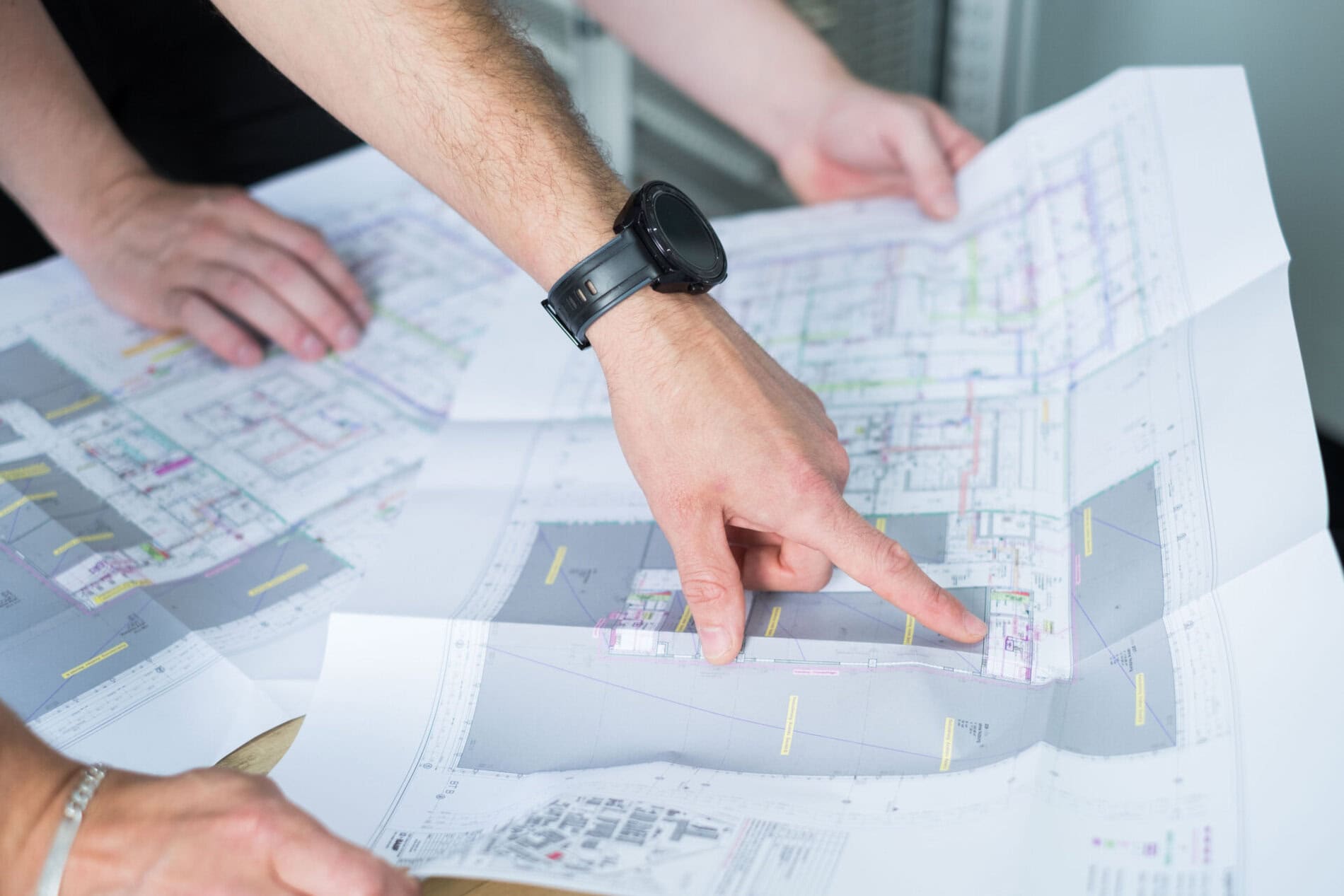 Hand zeigt auf einen technischen Plan.